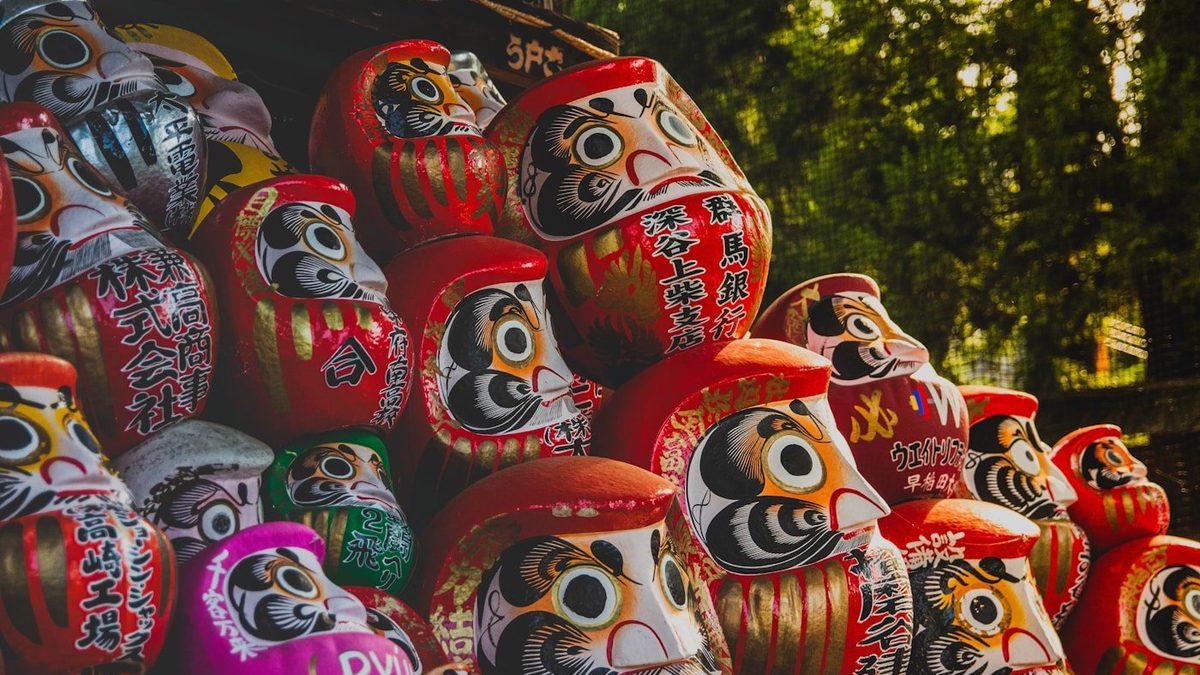 Darumas japonais colorés alignés dans un temple traditionnel