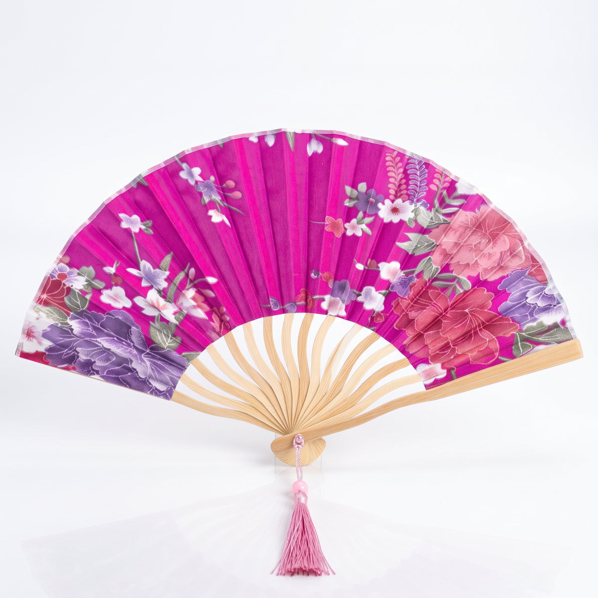 Éventail japonais fleuri rose fuchsia en forme de coquille, fleurs et feuillages, pompon rose