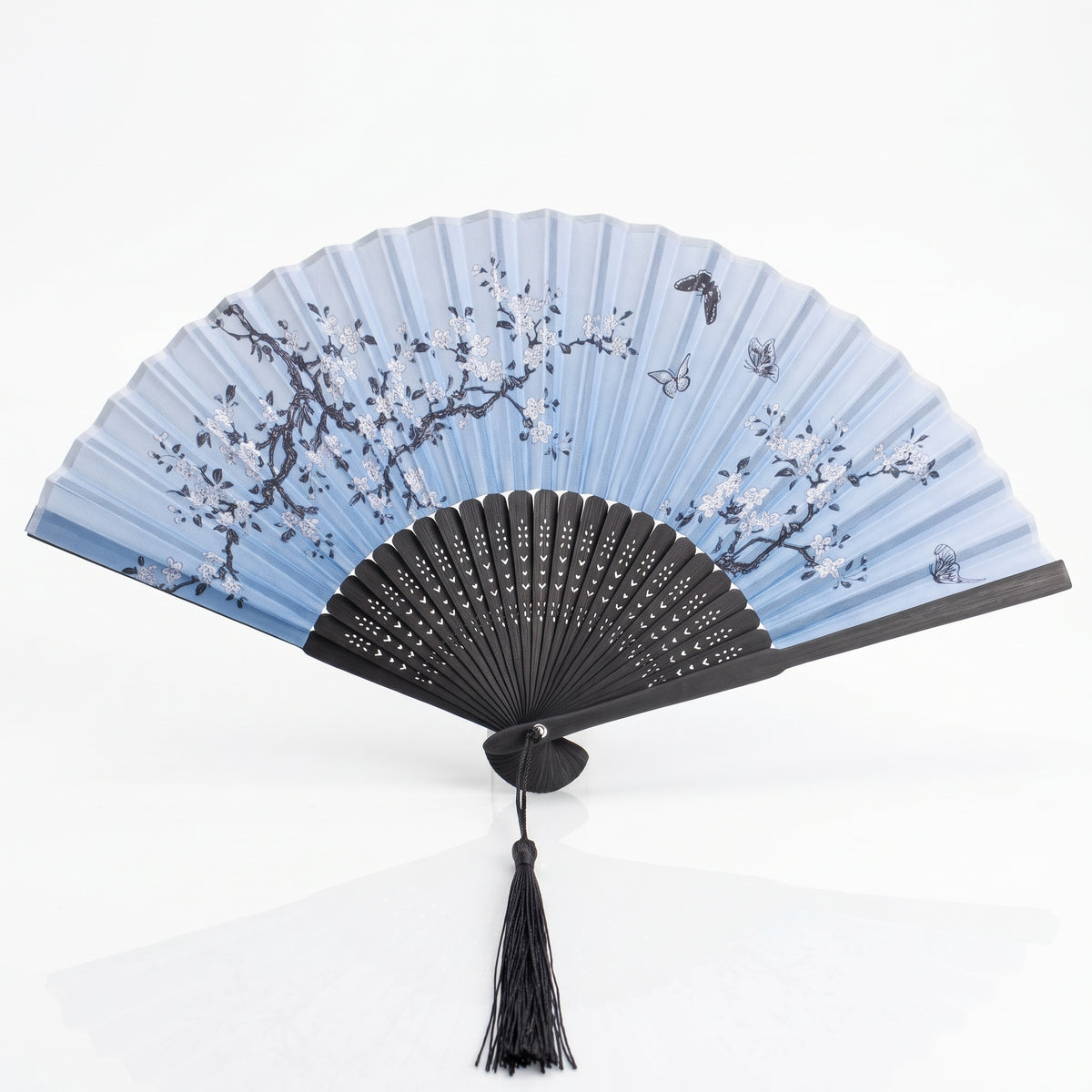 Éventail japonais nature bleu ouvert, branches fleuries et papillons sur bleu clair, monture noire et pompon noir