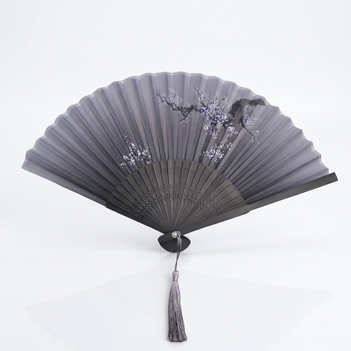 Éventail japonais nature gris ouvert, branche fleurie et oiseau sur gris dégradé, monture noire et pompon gris