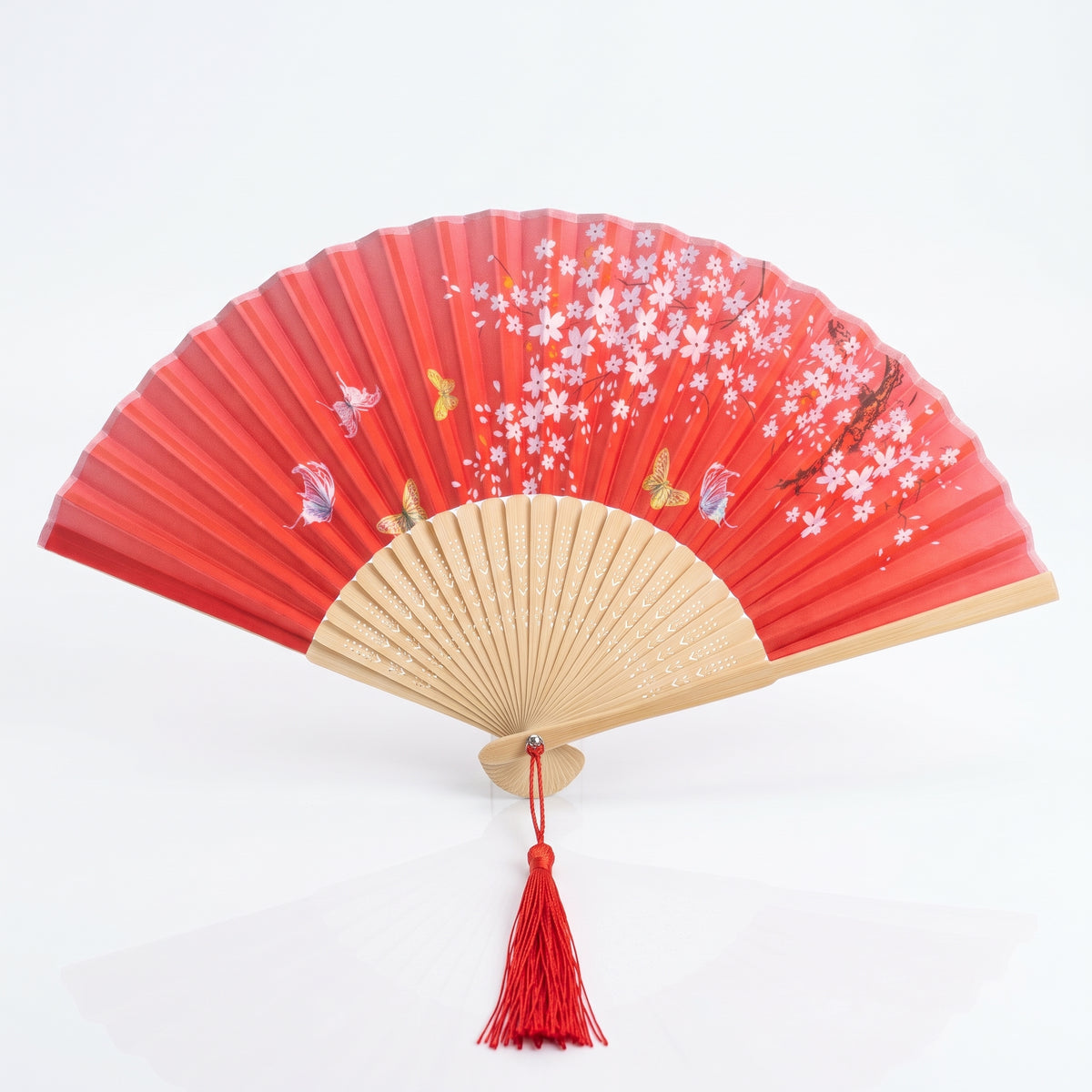Éventail japonais nature rouge ouvert, fleurs blanches et roses et papillons, monture claire et pompon rouge