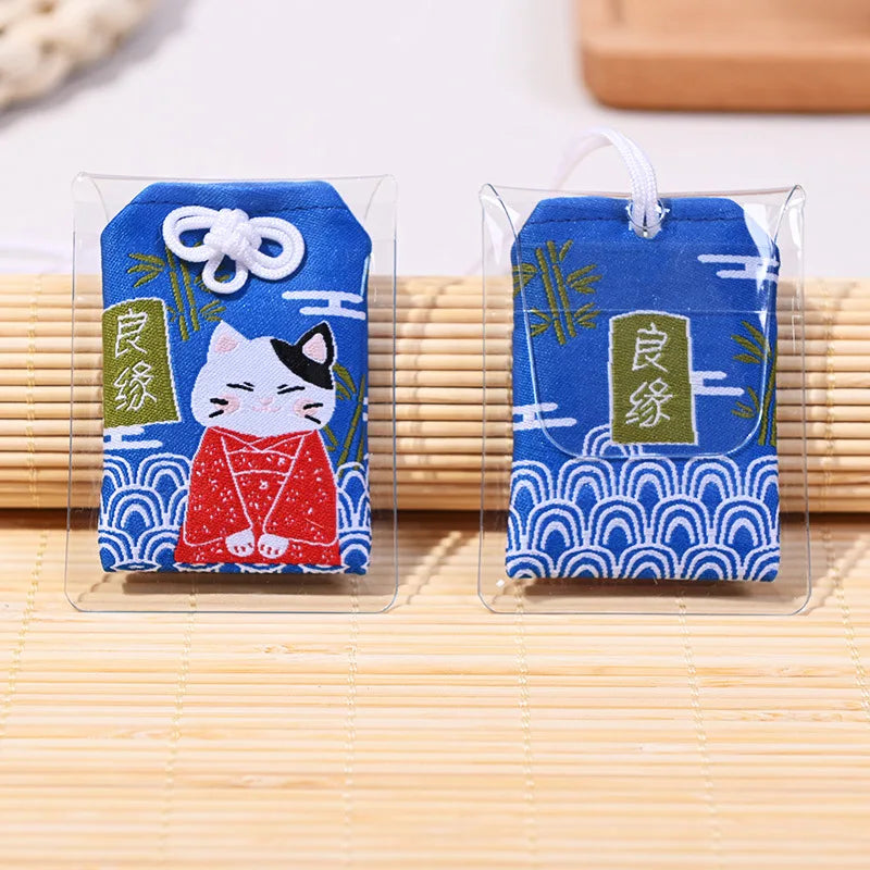 Omamori bleu japonais brodé avec Maneki-Neko pour attirer les bonnes relations et l'amour.