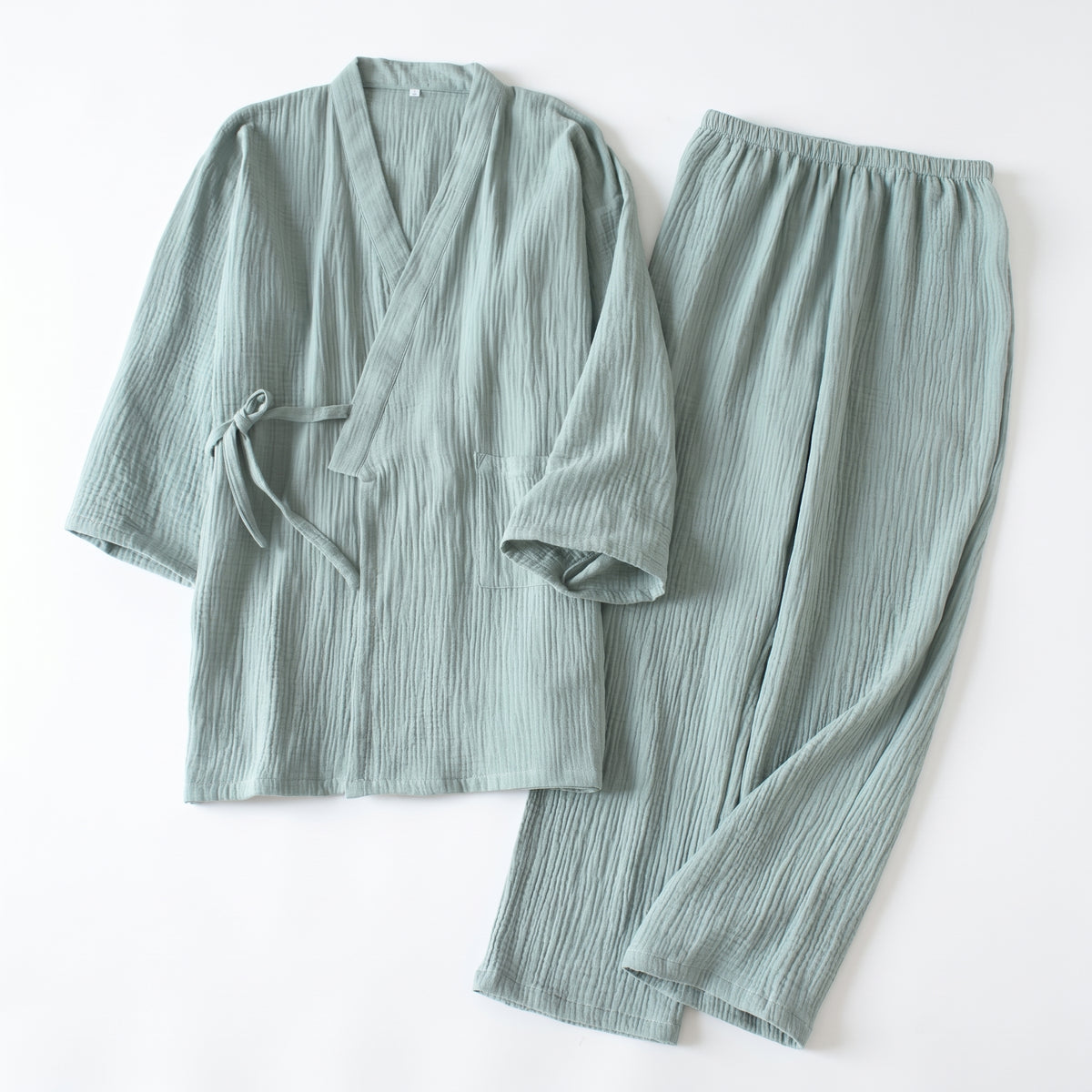 Pyjama japonais vert clair en gaze de coton, haut croisé noué sur le côté et pantalon long posés à plat