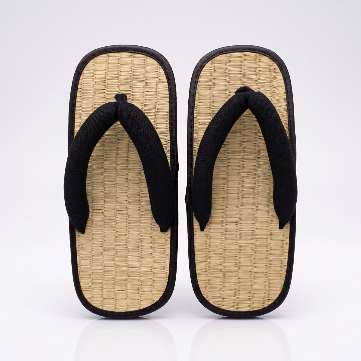 Paire de sandales japonaises zori noires vue de dessus : dessus tressé couleur paille et lanières noires rembourrées