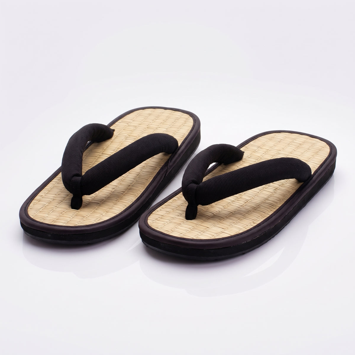 Paire de sandales japonaises zori noires, dessus tressé couleur paille, liseré noir et lanière noire rembourrée