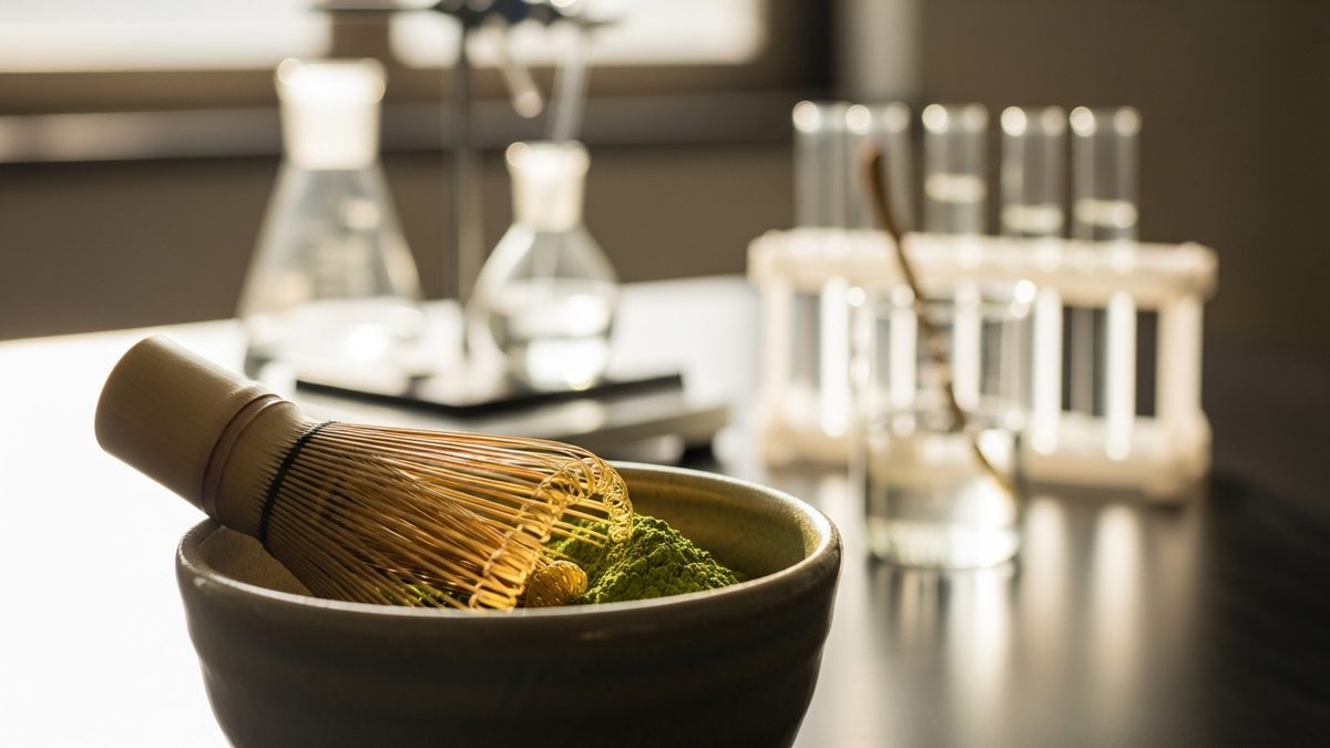 Poudre de matcha dans un bol avec chasen et éléments de recherche scientifique