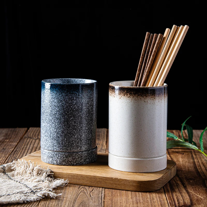 Deux pots à ustensiles japonais en céramique avec baguettes sur planche