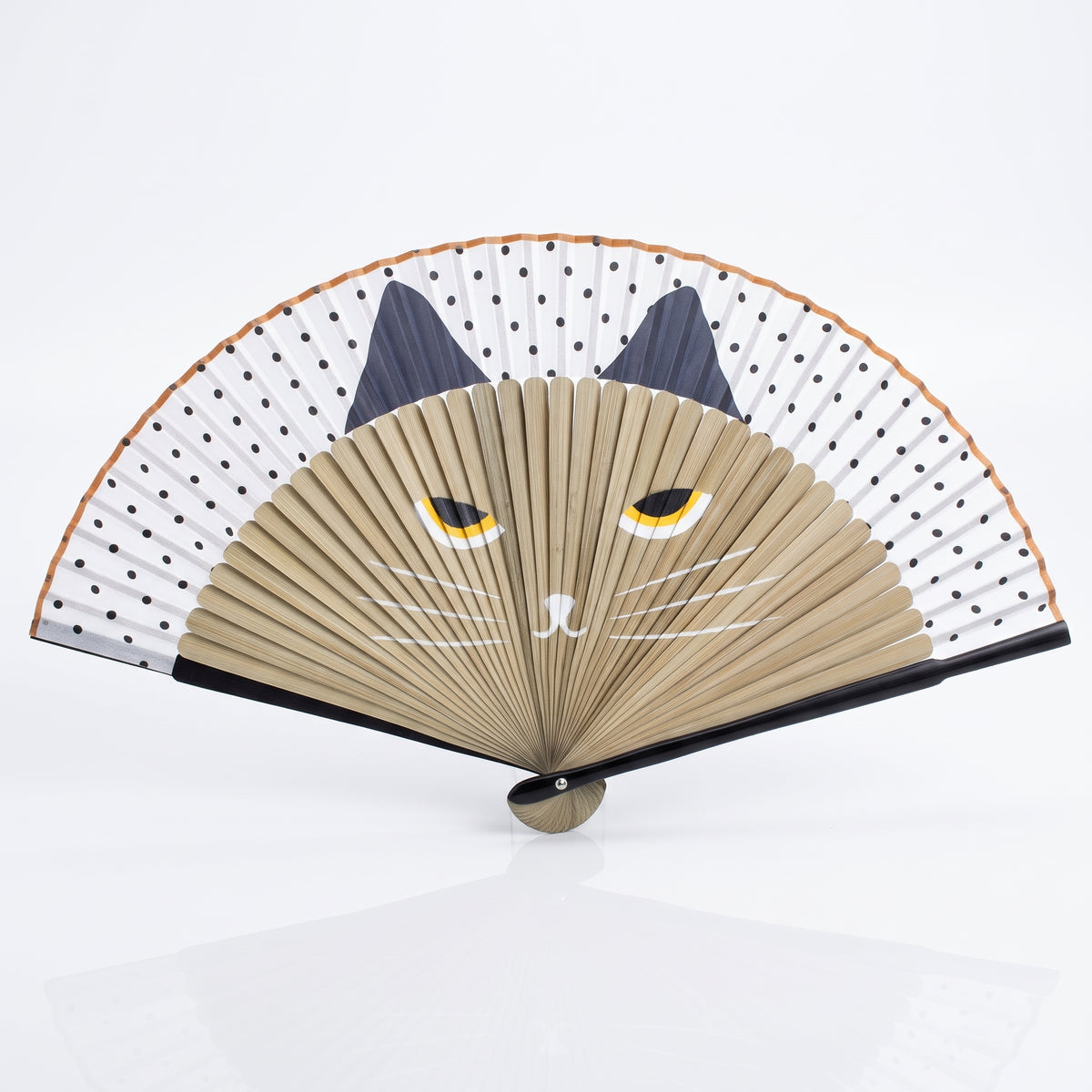 Éventail japonais chat beige ouvert, chat beige aux oreilles bleu marine sous une feuille blanche à pois noirs
