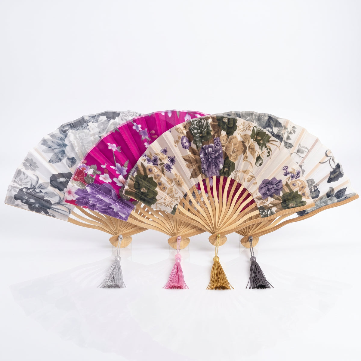Éventails japonais fleuris blanc, rose, beige et gris ouverts et groupés en éventail, chacun avec son pompon