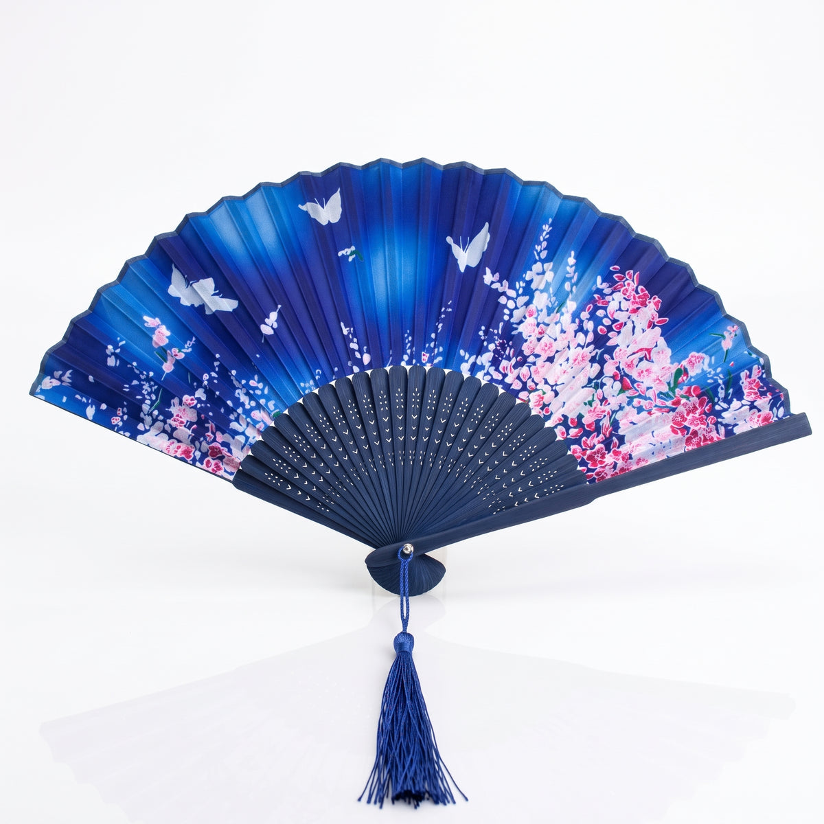 Éventail japonais nature bleu nuit ouvert, fleurs roses et papillons blancs, monture et pompon bleus