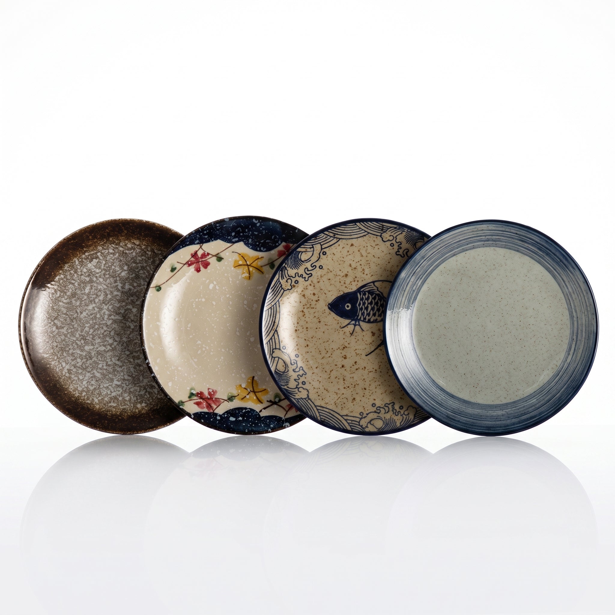 Quatre assiettes japonaises en céramique : motifs moucheté, érables, carpe et pinceau