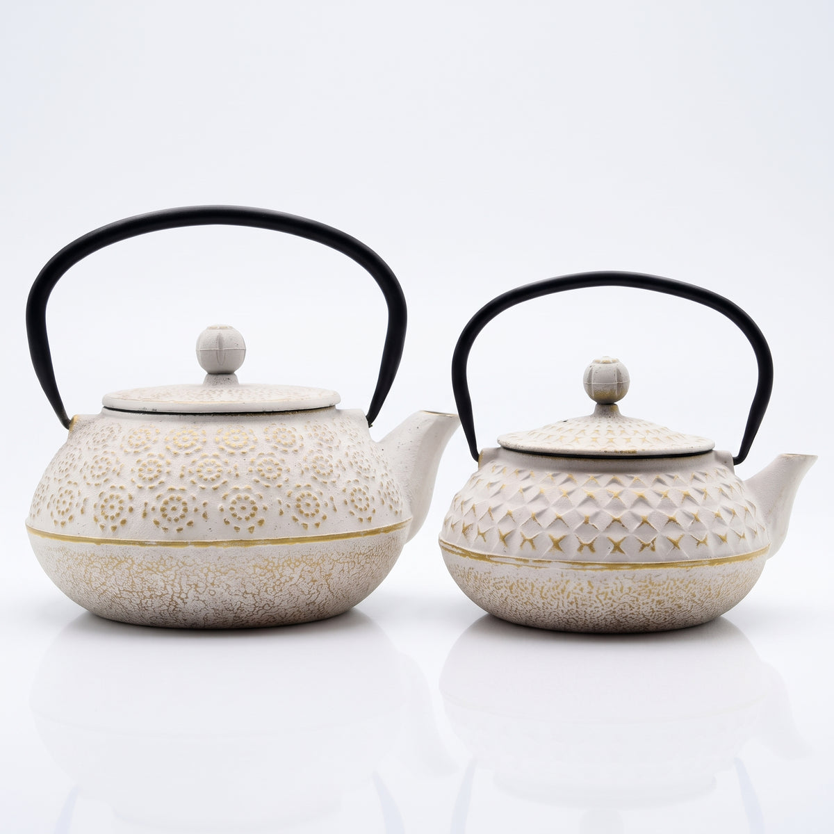 Théières japonaises en fonte blanche et or côte à côte : motif Fleurs dorées et motif Losanges dorés