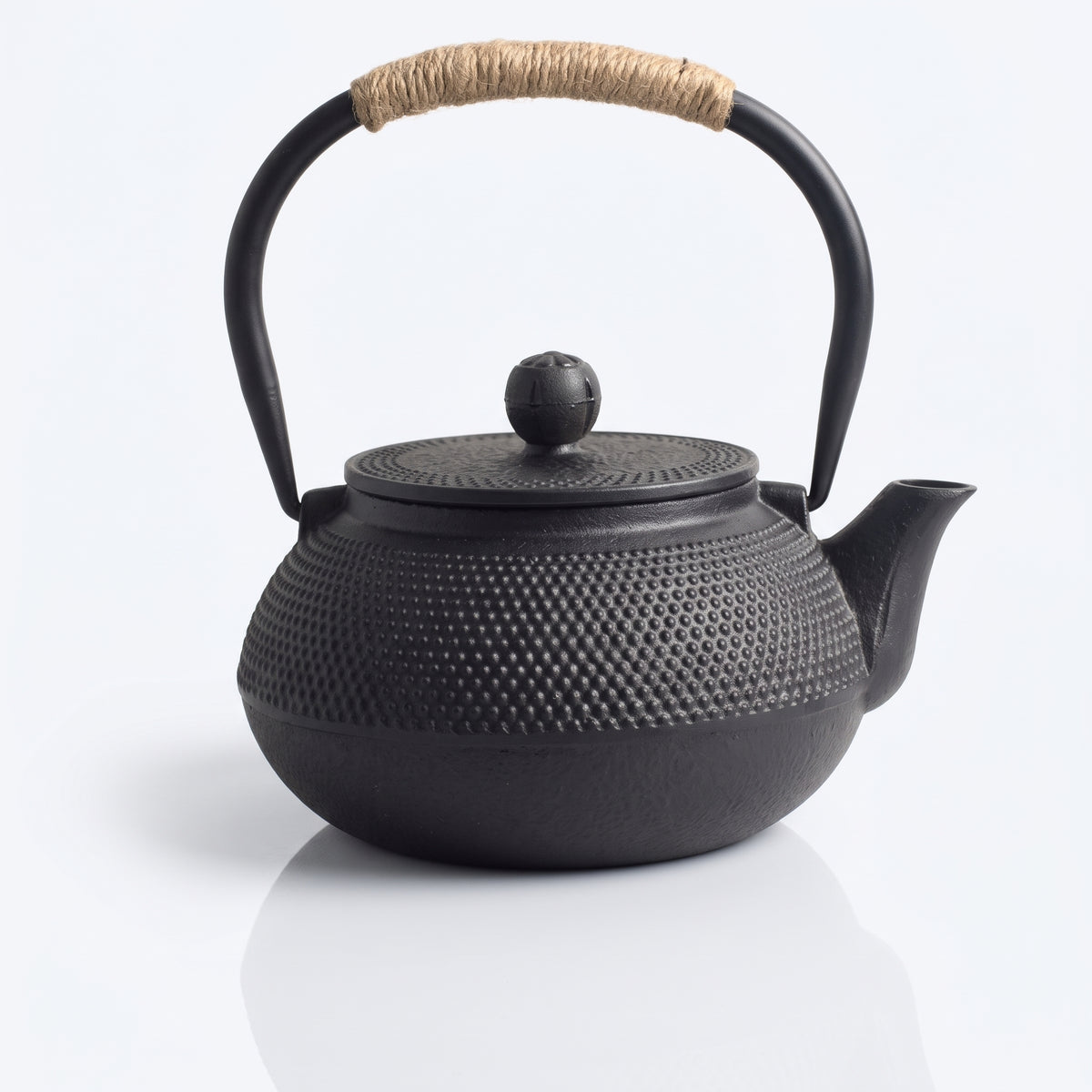 Théière japonaise en fonte noire à picots, anse gainée de cordelette, vue de face